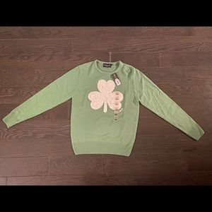 Green sweater, with a white clover